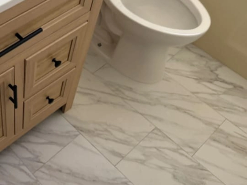 Bathroom with marble tile floor, vanity cabinet, and toilet.